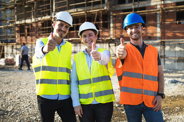 Wall Mural - Three construction workers having meeting,pose for the photographer,stock photo