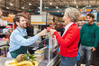 © Robert Kneschke - Kundin zahlt mit Kreditkarte an der Supermarkt Kasse