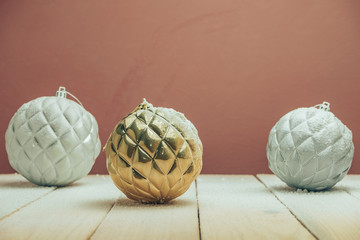 Poster - Beautiful Christmas baubles on a new wooden table fell by snow and dark red wall background behind.