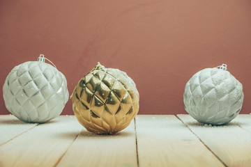 Poster - Beautiful Christmas baubles on a new wooden table fell by snow and dark red wall background behind.