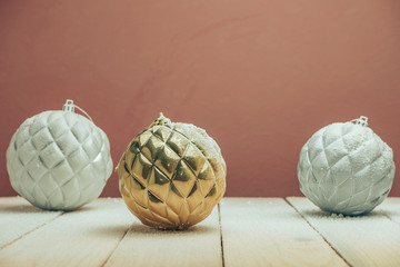 Poster - Beautiful Christmas baubles on a new wooden table fell by snow and dark red wall background behind.