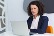 © Mangostar - Confused frowning businesswoman getting concerning news. Business woman sitting at white conference table, using laptop, staring at screen and reading. Bad news concept
