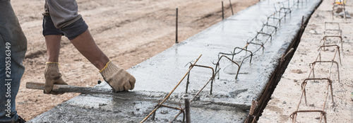 Fotomural Construction worker is leveling concrete pavement at road construction site