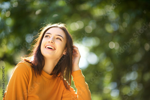 Fotografía Close up happy young woman laughing in park with hand in hair
