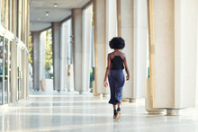 A Young Fashionable Afro-American Woman Walking Away From The Camera