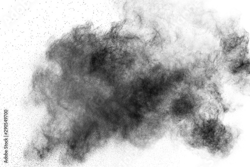 Black powder explosion against white background. Charcoal dust particles clou...