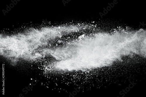 White powder explosion cloud against black background.White dust particles sp...