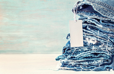 Wall Mural - A collection of old jeans on a blue background. Sale at the jeans store. 