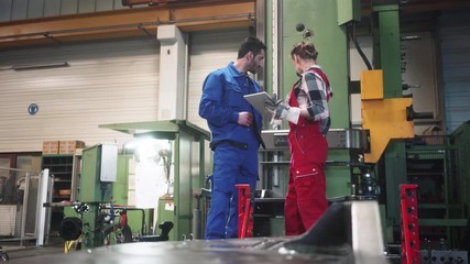 Wall Mural - Woman and man manufacturing worker in discussion