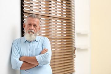 Sticker - Portrait of handsome mature man near window with blinds