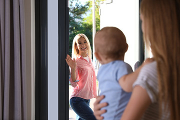 Canvas Print - Mother leaving her baby with teen nanny at home