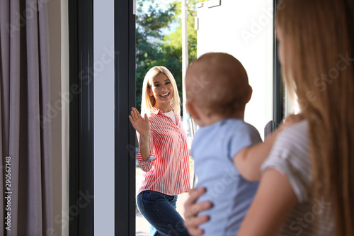 Fotografía Mother leaving her baby with teen nanny at home