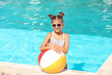 Poster - Cute little girl with inflatable ball in swimming pool