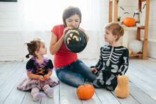 Happy Family Of Mother And Children Prepare For Halloween In Decorate The Home