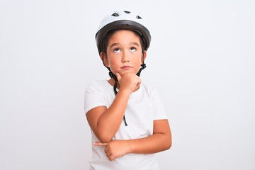 Wall Mural - Beautiful kid boy wearing bike security helmet standing over isolated white background with hand on chin thinking about question, pensive expression. Smiling with thoughtful face. Doubt concept.