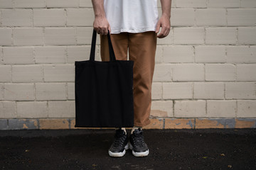 man holding cotton black tote bag