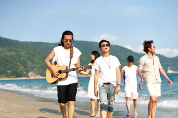 group of asian young men walking on beach