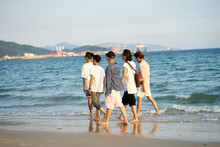 Group Of Asian Men Walking On Beach