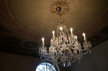 Ornamental Chandelier Made Of Glass Near The Ceiling.