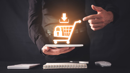 Canvas Print - businessman holding a tablet with a shopping cart. shopping security. online shopping