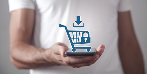 Canvas Print - businessman holding a phone with a shopping cart. shopping security. online shopping
