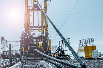 Wall Mural - Offshore oil rig worker prepare tool and equipment for perforation oil and gas well at wellhead platform. Making up a drill pipe connection. A view for drill pipe connection from between the stands