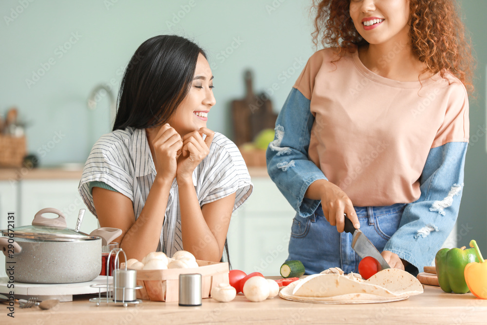 Beautiful women cooking together in kitchen