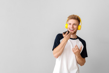 Sticker - Handsome young man listening to music on light background