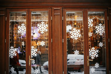 Christmas Street Decor. Stylish Christmas Lights And Snowflakes At Wooden Window Store Front At Holiday Market In City Street. Space For Text. Rustic Decor