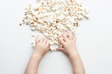 hands child take salted popcorn from a white background