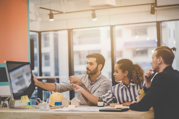 Team of young Real Estate Contractor home developer  is brainstorming in office. Three modern business peopler is discussion in a meeting for Business success.