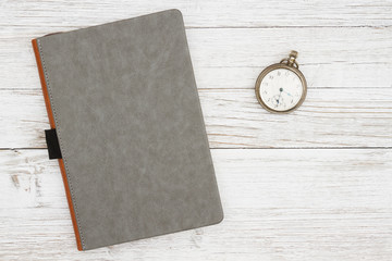 Wall Mural - Blank gray journal with pocket watch on a weathered whitewash wood background