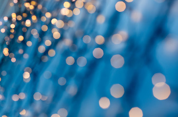 Wall Mural - holiday, illumination and decoration concept - bokeh of christmas garland lights over dark blue background
