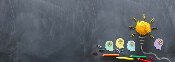 Wall Mural - Education concept image. Creative idea and innovation. Crumpled paper as light bulb metaphor over blackboard
