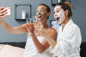 Poster - Women drinking champagne take selfie by mobile phone.