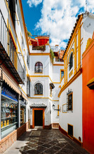 Old Picturesque Passageway In The Medieval Jewish Quarter Of Santa Cruz In Seville, Andalusia, Spain