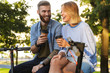 © Drobot Dean - Image of laughing couple drinking coffee while sitting on railing