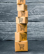 Tower of cardboard boxes with pattern of shopping carts on a blue background. commerce, online shopping. Purchasing power, delivery order. E-commerce, logistics, distribution and sales.