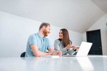 Wall Mural - Low angle image of smiling businesswoman talking to a male client in bright office, copy space.