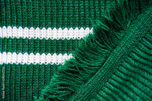 Fotografía Knitted texture of green warm scarf with white stripes and fringe
