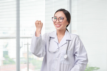 Wall Mural - Young medical doctor woman standing on hospital background.