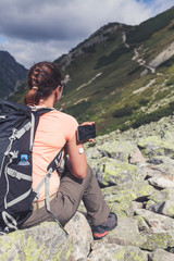 Wall Mural - Active life of diabetics, woman hiking and checking glucose level with a remote sensor and mobile phone, sensor checkup glucose levels without blood