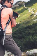 Wall Mural - Active life of diabetics, woman hiking and checking glucose level with a remote sensor and mobile phone, sensor checkup glucose levels without blood