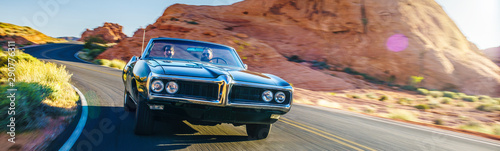 Fotografía couple driving together in cool vintage car through desert
