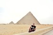 Man sitting with pyramids in giza view 