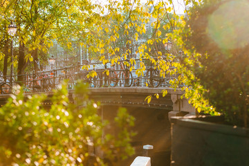 Wall Mural - Bicycle parked on a bridge above the water in Amsterdam at sunset.