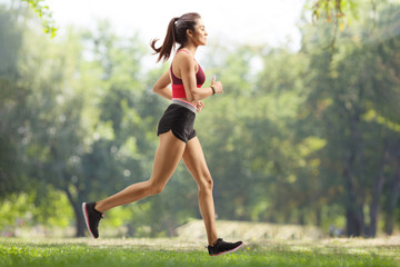 Wall Mural - Young female athlete jogging outdoors