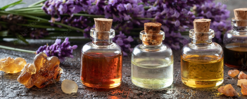 Panoramic header of essential oil bottles, frankincense and lavender - obrazy, fototapety, plakaty 