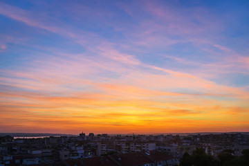 Wall Mural - beautiful skyscape at the sunset time over a small city. vivid sky of golden and orange colors durin