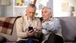 © motortion - Two mature friends learning to use smartphone application, modern technology